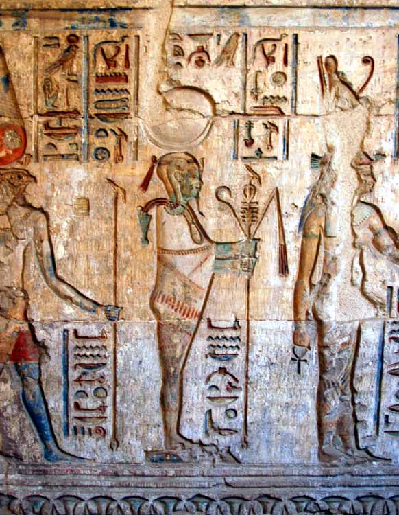 In the vestibule with the door to the last Chapel to the left and the entrance to the Courtyard to the right.  Scenes of Ptolemy offering to various Gods.  This one is of the moon god Khonsu,  the son of Amun and Mut.
